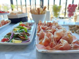 two plates of food on a table with food at DESIGN hotel VERBENICUM in Vrbnik
