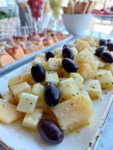 a plate of food with cheese and olives on it at DESIGN hotel VERBENICUM in Vrbnik