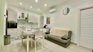 a kitchen and dining room with a table and a couch at Appartamento Casa Crispino Piano terra per 2 persone in Frattaminore