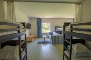 a dorm room with bunk beds and a living room at Systemairhallen Bed&Breakfast in Skinnskatteberg