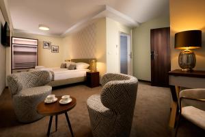 克拉科夫的住宿－Xerion Hotel，酒店客房配有一张床、两把椅子和一张桌子