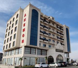 un gran edificio con coches estacionados frente a él en ANEMON MARDIN OTEL, en Mardin