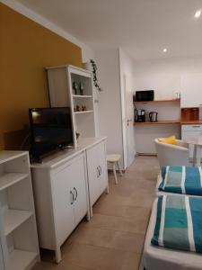 a living room with a tv on a white cabinet at Landlust! in Hoyerswerda