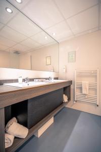 een badkamer met een wastafel en een grote spiegel bij Hotel Royal Astrid in Oostende