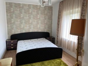 a small bedroom with a bed and a window at Rózsa Vendégház Balatonfüred in Balatonfüred