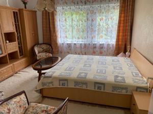 a bedroom with a bed and a window and chairs at Rózsa Vendégház Balatonfüred in Balatonfüred