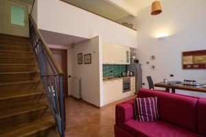 a living room with a red couch and a kitchen at San Gregorio Luxury Apartments in Naples