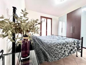 a bedroom with a bed and a vase with a plant at Locazione Turistica Casa LALLI in Pieve a Maiano