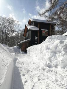 小谷村的住宿－HIEDA SANSO，围栏旁的雪地房子