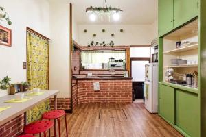 a kitchen with green cabinets and red stools at Forest Villa Hakone in Hakone