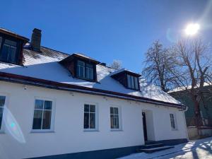 uma casa branca com neve no telhado em Bühnenwirtshaus Juster em Gutenbrunn