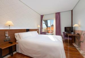 a hotel room with a large white bed and a window at Hotel Murcia Rincón de Pepe Affiliated by Meliá in Murcia