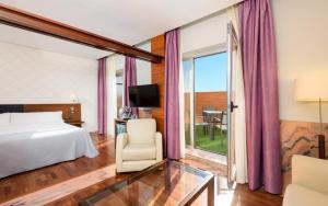 a hotel room with a bed and a chair and a window at Hotel Murcia Rincón de Pepe Affiliated by Meliá in Murcia