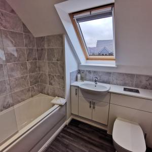 a bathroom with a sink toilet and a window at Number 27 in Ullapool