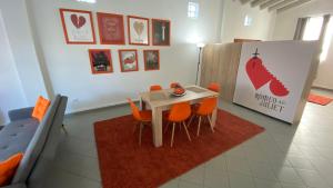 a dining room with a table and orange chairs at Patras Romeο House in Patra