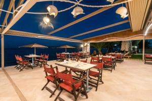 een eetkamer met tafels en stoelen en blauwe plafonds bij Avantis Suites Hotel in Eretria