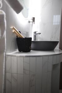 a bathroom counter with a sink and a basket on it at ODI ARTSPITALITY in Volos