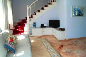 a living room with a couch and a tv and stairs at Holiday Home Witsum - DNS10055-F in Hedehusum