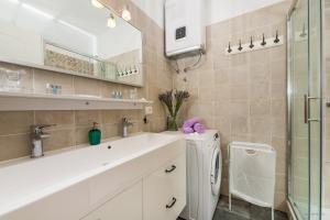 a bathroom with a sink and a washing machine at Aldo Apartments Center in Zadar
