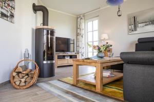 a living room with a fireplace and a stove at Holiday house, Fuhlendorf in Fuhlendorf