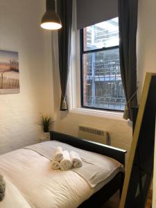 a bedroom with towels on a bed with a window at The Stanhoe in Leicester