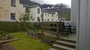 a deck with chairs and a table in a yard at Private House with Private Garden in Ísafjörður