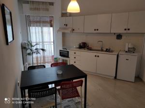 a kitchen with a black table and red chairs at Square in Komotini