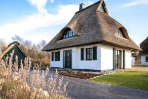 a thatched cottage with a grass roof at Holiday house, Fuhlendorf in Fuhlendorf