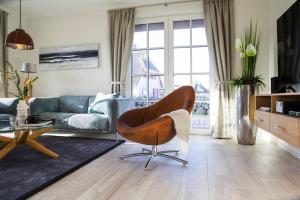 a living room with a couch and a chair at Holiday house, Fuhlendorf in Fuhlendorf