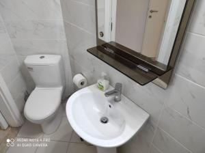 a bathroom with a sink and a toilet and a mirror at Square in Komotini