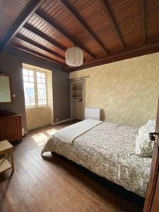 a bedroom with a bed and a wooden ceiling at LES CLAPOTIS RUE DU PHARE QUIBERON in Quiberon