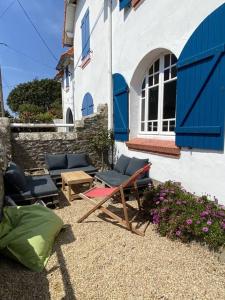 a patio with chairs and a table and a building at LES CLAPOTIS RUE DU PHARE QUIBERON in Quiberon