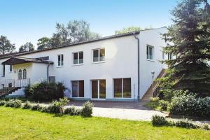 a white house with a tree in front of it at Reihenhaus Seeblick, Sommersdorf in Sommersdorf