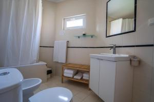 a bathroom with a sink and a toilet and a mirror at Quinta da Bicuda in Cascais