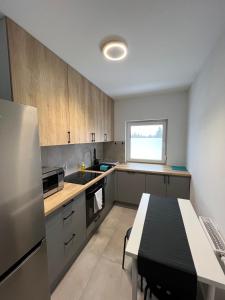 a kitchen with wooden cabinets and a table in it at Abra Apartament in Poznań