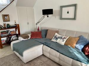 a couch with pillows on it in a living room at The Nook - Balatonkiliti in Siófok