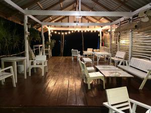 a patio with white chairs and tables and lights at BOHO Hostel in Ko Lanta