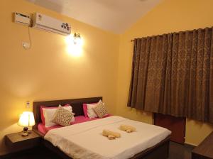 1 dormitorio con 2 ositos de peluche en la cama en Jas Guest House en Mobor Goa