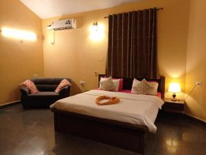 1 dormitorio con 1 cama y 1 silla en Jas Guest House, en Mobor Goa