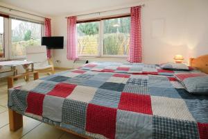 um quarto com uma cama com uma colcha vermelha e azul em Bungalow summer house, Parchim em Parchim