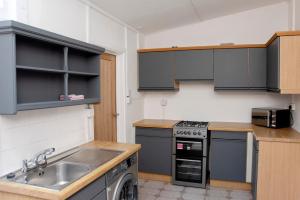 a kitchen with a sink and a stove top oven at Six Bells Retreat in Abertillery