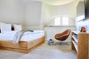 um quarto com uma cama e uma cadeira em Holiday house, Fuhlendorf em Fuhlendorf