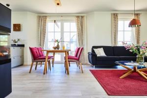 a living room with a table and red chairs at Holiday house, Fuhlendorf in Fuhlendorf