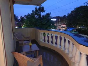 balcón con mesa, sillas y vistas en Jas Guest House en Mobor Goa