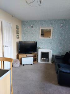 a living room with a flat screen tv and a fireplace at 1st Floor Hillview 2 bedrooms central location in Brean