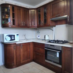 a kitchen with wooden cabinets and a stove top oven at Гагарин in Pyatigorsk