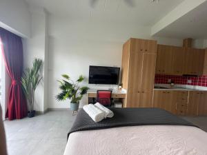 a bedroom with a bed and a desk and a tv at Rayong Condochain by Rick in Rayong