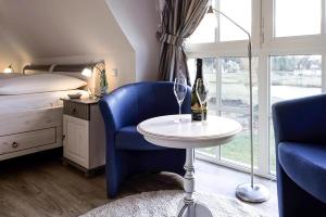a bedroom with a bed and a table and a bottle of wine at Holiday house, Fuhlendorf in Fuhlendorf