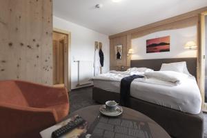 um quarto de hotel com duas camas e uma mesa com controlo remoto em Aktiv-Hotel Traube em Wildermieming