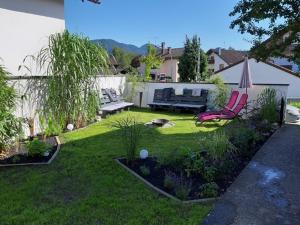 a garden with a bench and chairs in a yard at Florentiner Haus in Kiefersfelden